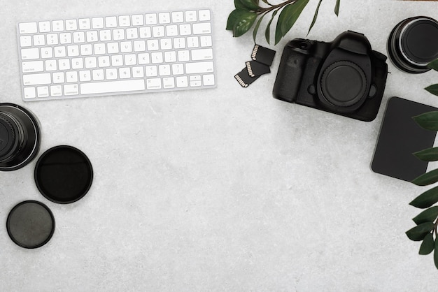 Foto bovenaanzicht van werkruimtefotograaf met digitale cameralenzen, geheugenkaart en camera-accessoire op tafel