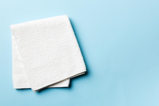 Bovenaanzicht van witte handdoeken met kopieerruimte op gekleurde achtergrond