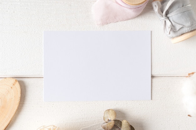 Foto bovenaanzicht van witte werktafel met blanco papieren notitieblok, natuur katoen. platliggende stillevenkaars, gouden paperclips. kladblok en pen.