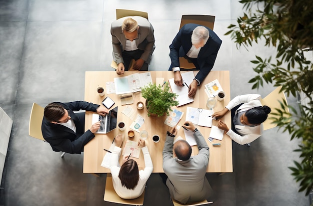 Bovenaanzicht van zakenmensen die aan tafel zitten en samenwerken op kantoor