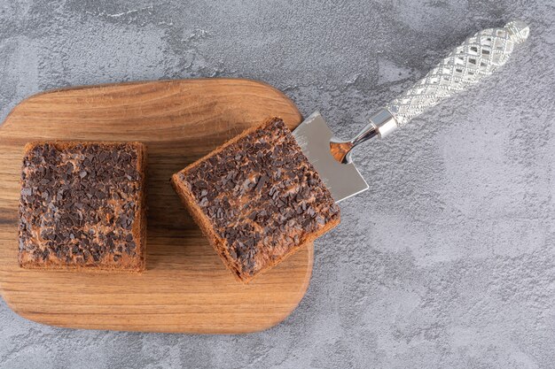 Bovenaanzicht van zelfgemaakte chocoladetaart plakjes op een houten bord.