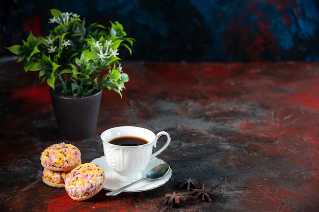 Bovenaanzicht van zelfgemaakte heerlijke suikerkoekjes en een kopje koffiebloempot aan de rechterkant op donkere mixkleurenachtergrond met vrije ruimte