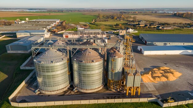 Bovenaanzicht van zilveren silo's op agro-fabriek voor het verwerken van drogen, reinigen en opslaan van landbouwproducten meel, granen en graan Grote ijzeren vaten van graan Graanschuurlift