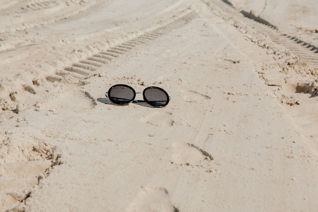 Bovenaanzicht van zonnebril op het strand