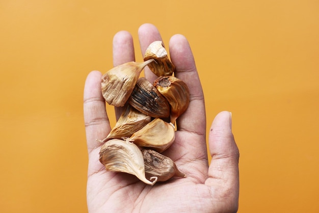 Bovenaanzicht van zwarte knoflook bij de hand