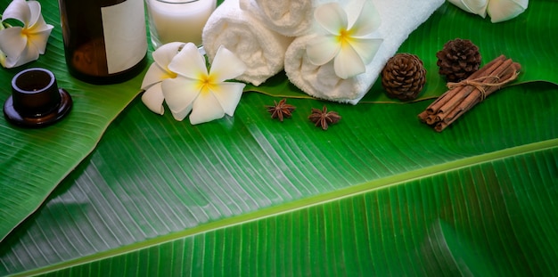 Bovenaanzicht van zwarte stenen en handdoeken voor massages op groene bananenbladeren