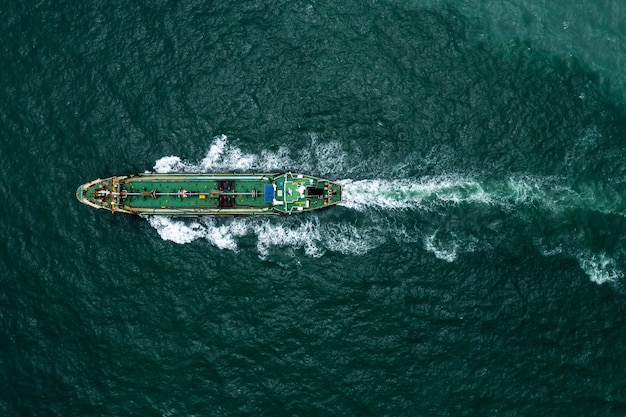 Bovenaanzicht vanuit de lucht Olietanker die op volle snelheid vaart met golf- en spatwater in lijn