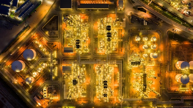 Bovenaanzicht vanuit de lucht van de elektriciteitscentrale van de chemische olieraffinaderij en metalen pijp op de achtergrond van de avondrood