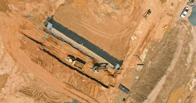 Bovenaanzicht vanuit de lucht van graafmachine laadt aarde naar de dumper zijn zware bouwmachines van