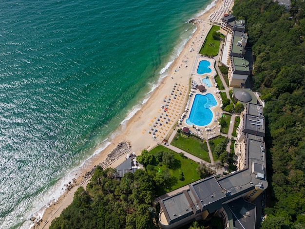 Bovenaanzicht vanuit de lucht van het Golden Sands-resort in Bulgarije tijdens het zomerseizoen, een scala aan hotels, zwembaden en mensenmassa's die genieten van de zee