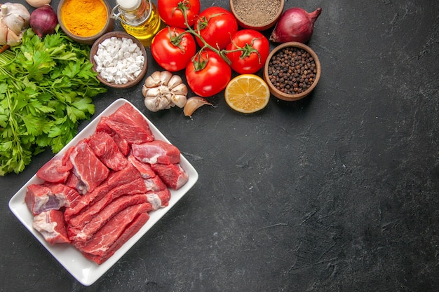 bovenaanzicht vers gesneden vlees met kruiden greens en rode tomaten