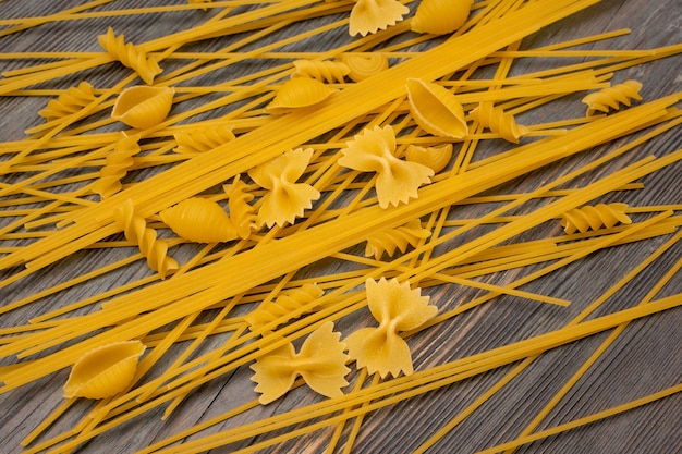 Foto bovenaanzicht verschillende soorten italiaanse pasta op houten achtergrond