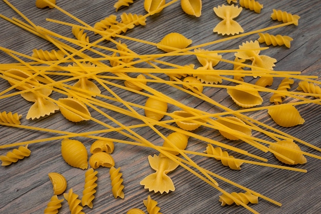 Foto bovenaanzicht verschillende soorten italiaanse pasta op houten achtergrond