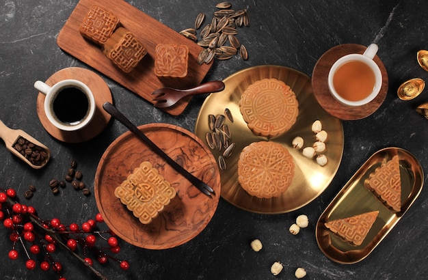 Bovenaanzicht verschillende vorm Moon Cake (Mooncake) Chinese Dessert Snack tijdens Lunar New Year Mid Autumn Festival. Concept Rustica Black Asian Bakery, geserveerd met thee en koffie. Ruimte kopiëren