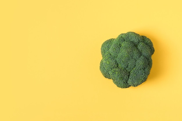 Bovenaanzicht verse groene broccoli groente op gele Broccoli kool kop op een gekleurde achtergrond