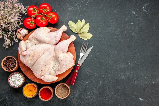 bovenaanzicht verse kip met tomaten en kruiden