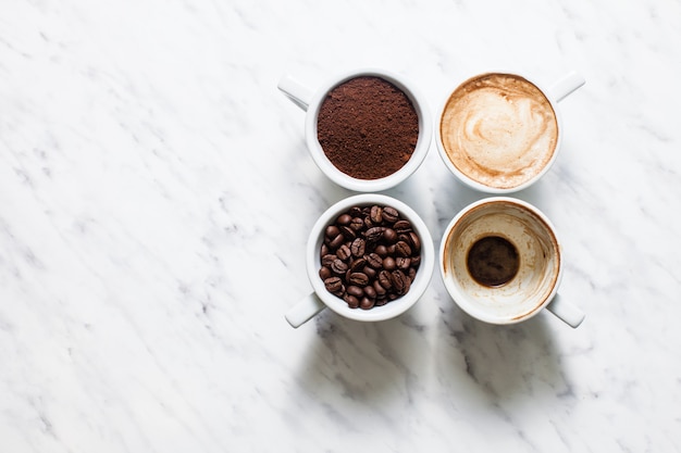 Bovenaanzicht vijf kopjes van verschillende stadia van het bereiden van cappuccino met kopieerruimte