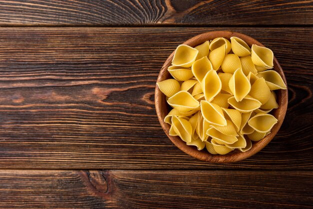 Bovenaanzicht volkoren pasta op donkere houten tafel