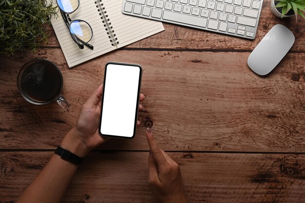 Bovenaanzicht vrouw met mock up mobiele telefoon met leeg scherm