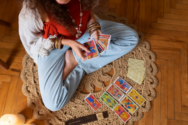 Foto bovenaanzicht vrouw tarot thuis lezen