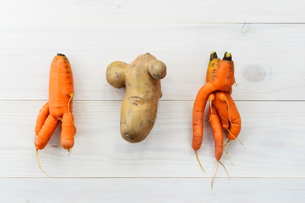 bovenaanzicht wortelen en aardappel op tafel