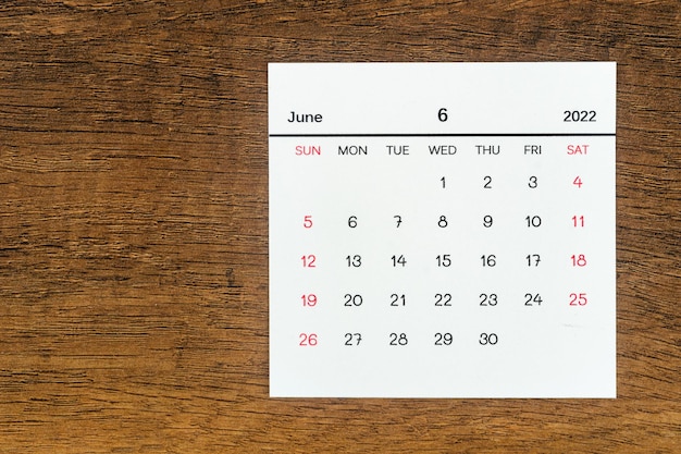 Bovenaanzichten Kalenderbureau Juni is de maand voor organisatoren om te plannen en eraan te herinneren op de houten tafelachtergrond
