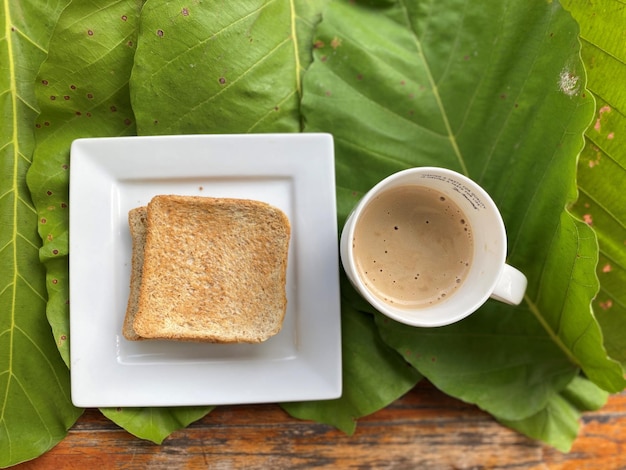Bovenbeeld van een kop koffie en toast op houten achtergrond