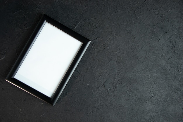 Bovenbeeld van een leeg fotoram op een donkere muur