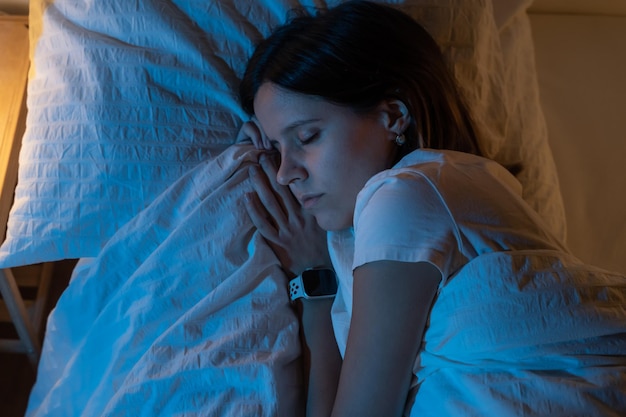 Bovenbeeld van een mooi meisje dat gezellig op een bed in haar slaapkamer slaapt