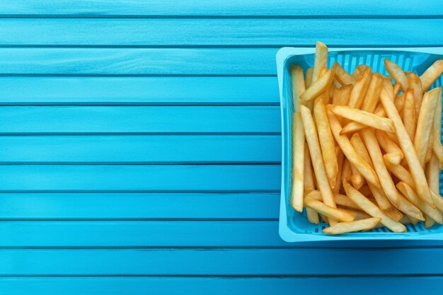 Bovenbeeld van smakelijke aardappelchips op een emmer met een glas cola op een blauwe houten tafel