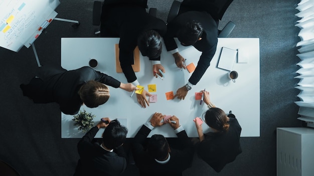 Bovenbeeld van zakenmensen die marketingideeën op plaknoten schrijven