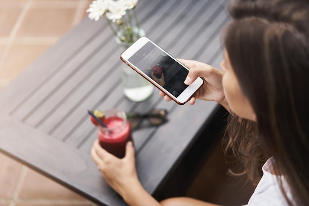 Bovenste hoek bijgesneden schot vrouw handen met smartphone open cam