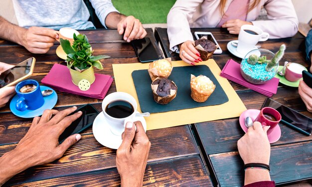 Bovenste hoekmening van mensen met telefoons bij coffeeshop-restaurant