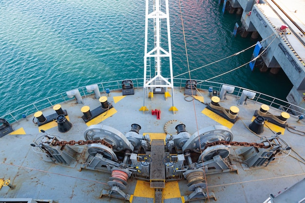 Photo the bow of a cargo ship moored to the pier with mooring winches on the deck top view