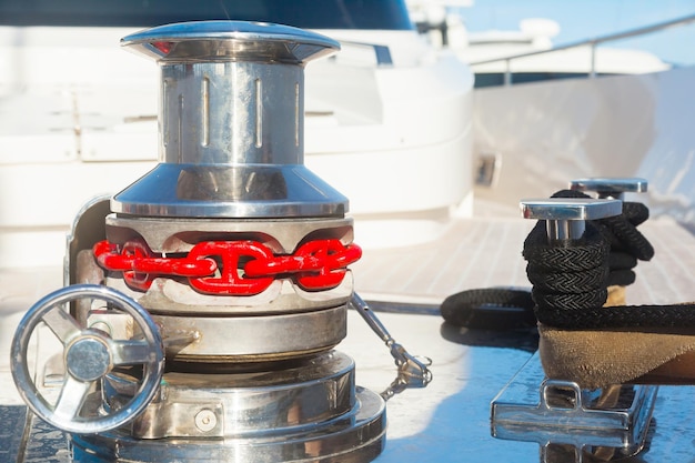 Photo bow of the yacht with anchor stops winch bollard with a mooring rope fixed and part of anchor chain