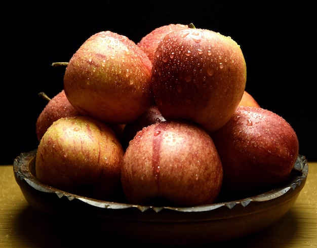 Photo a bowl of apples with water droplets on them