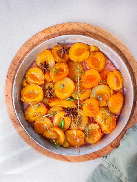 A bowl of apricots with rosemary and rosemary on top.