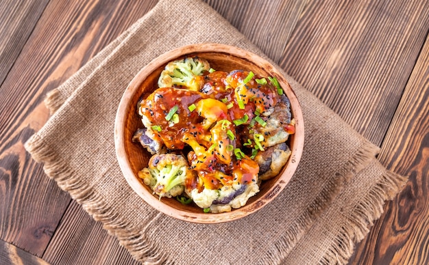 Bowl of asian fried cauliflower with sweet chili sauce