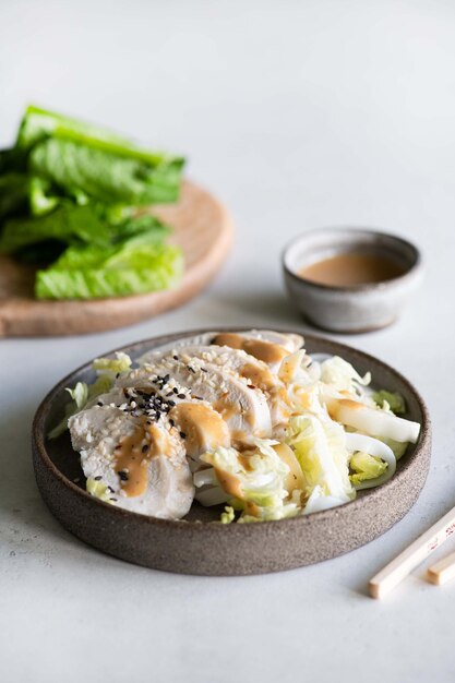 Photo a bowl of asian salad with a chopsticks next to it.