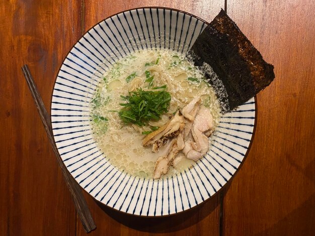 Bowl of authentic and mouth watering japanese ramen with creamy broth topped with chicken egg mushroom spring onion and seaweed