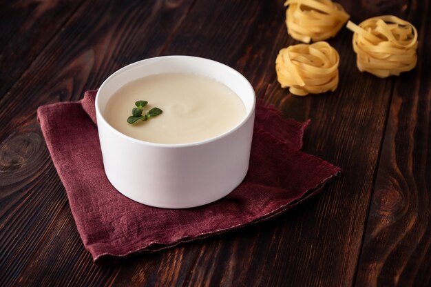 Photo bowl of bechamel sauce with tagliatelle pasta