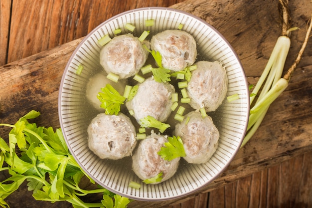 A bowl of beef ball soup on a wooden board