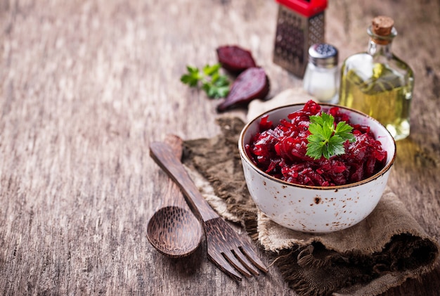 Photo bowl of beetroot salad on wooden background