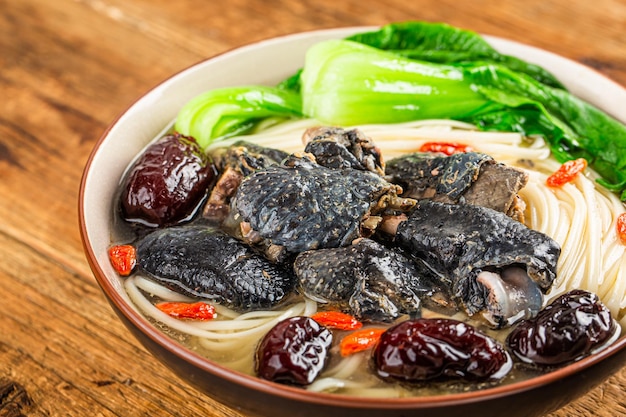 A bowl of black chicken noodles