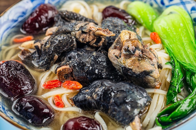 A bowl of black chicken noodles