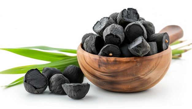 a bowl of black and white grapes and leaves with a green leaf