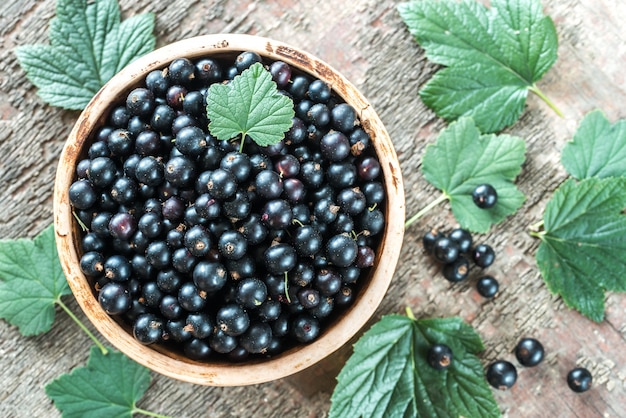 Bowl of blackcurrant on wooden board