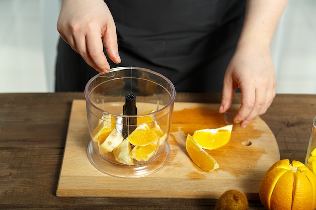 In the bowl of the blender are orange slices