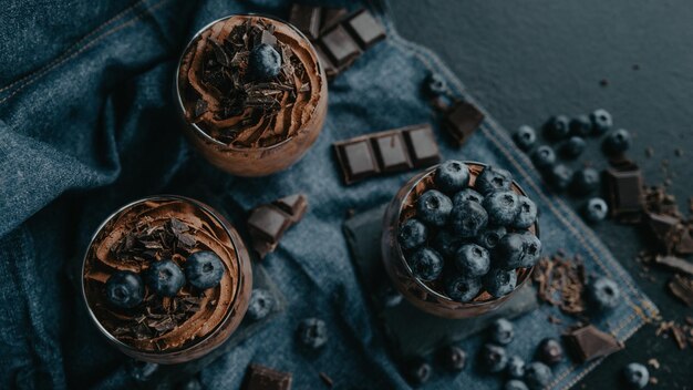 a bowl of blueberries and chocolate sit on a denim jacket