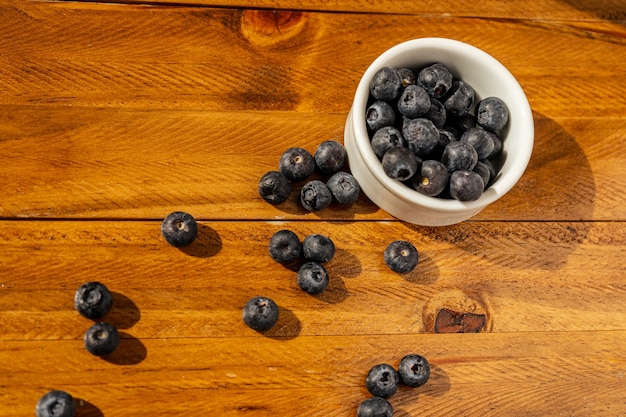 Bowl of blueberries on wooden table. Healty fruit.